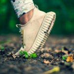 White running shoe on muddy ground