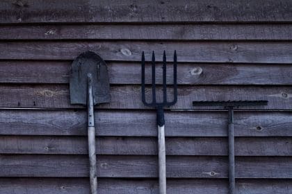 Rhos community garden in Wrexham. Image shows some gardening tools leaning up against a shed.