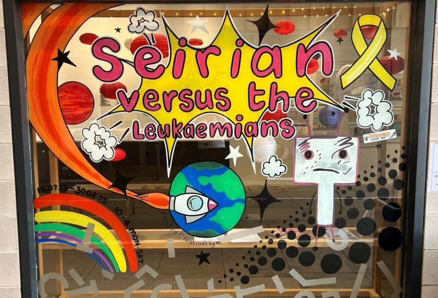 Bright cartoon window art by ‘PaintedCreations by ME’ (Michelle Edwards) for ‘Seirian versus the Leukamians’ exhibition at Tŷ Pawb, Wrexham