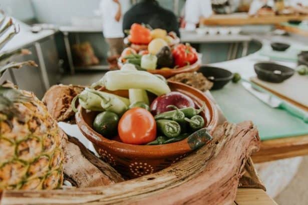 Foods including pineapple, tomato and peppers on a worktop at a food workshop